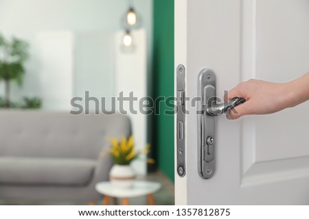 Woman opening door to stylish room, closeup. Interior design