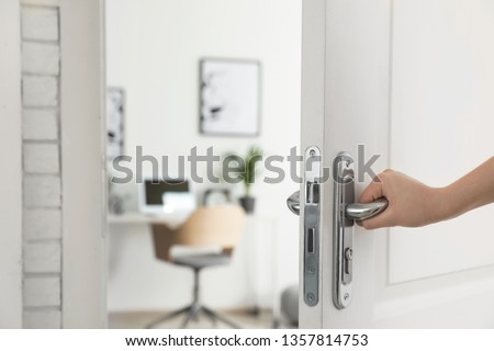 Woman opening door to stylish room, closeup. Interior design