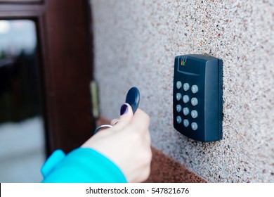 Woman opening house doors with electronic remote transmitter