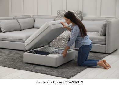 Woman Opening Modular Sofa Section With Storage In Living Room