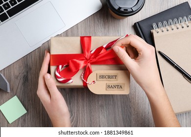 Woman Opening Present From Secret Santa At Workplace, Top View