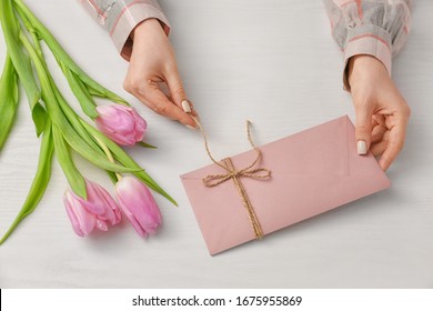 Woman Opening Received Letter At Table