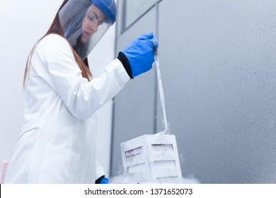 Woman Opening A Tank In A Cryogenic Lab