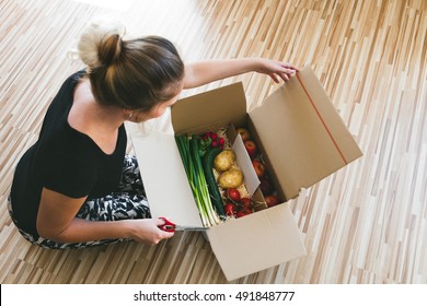 Woman Opening A Vegetable Delivery Box At Home, Online Ordering