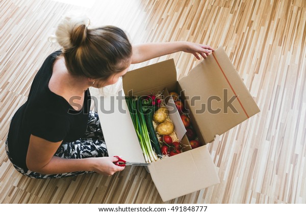 家庭で野菜の配達箱を開け オンラインで注文する人 の写真素材 今すぐ編集