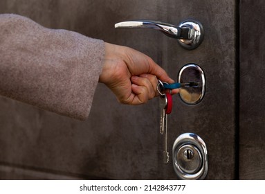 A Woman Opens The Front Door With Keys.Using Keys To Open And Close The Door Lock.The Landlord Opens The Door From A New House.