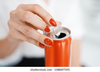 Woman opens a soda can after manicure,