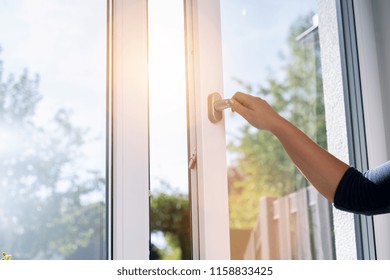 woman opens a window with a mosquito net - Powered by Shutterstock