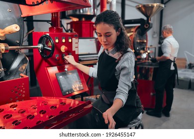 Woman Operating Coffee Roaster In His Factory.