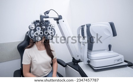 Woman optical shop happy customer doing eyesight measurement with optical phoropter check eye distance for eyeglasses is optical eye shop service.