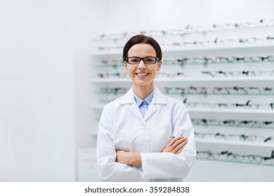 Woman Optician In Glasses And Coat At Optics Store