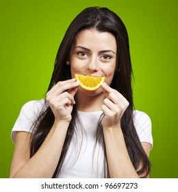 Woman With An Orange Slice As A Smile Against A Green Background