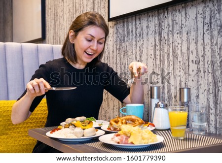 the woman ordered a lot of food in the restaurant and is going to eat all of it. good appetite in the restaurant