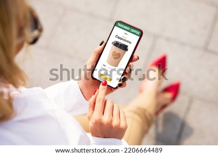 Woman ordering coffee online for takeaway on mobile phone