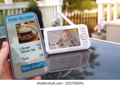 Woman Is Ordering  Food On  The Internet Using An App. Baby Monitor Behind