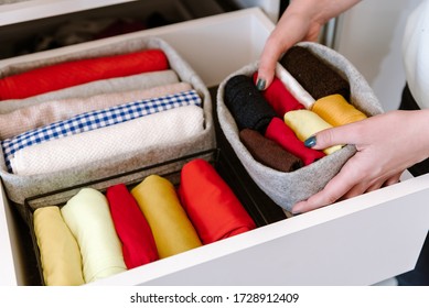 Woman Organizing Clothes In Wardrobe, Putting Stuff In Boxes, Baskets Into Shelves And Drawer. Concept Of Minimalism Lifestyle And Japanese T-shirt Folding System. Tidy Up Closet