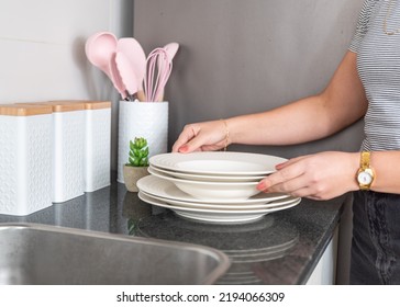 Woman Organizing Dishes In The Kitchen