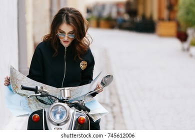 Woman In Original Sunglasses Sits On The Scooter With Touristic Map