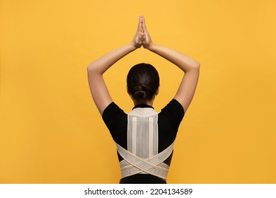 Woman With Orthopedic Corset On Orange Background, Back View