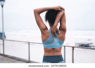 Woman, outdoor and stretching arms for warm up, runner and training on promenade for fitness. Female person, back and flexibility for muscle or athlete for health, cloudy sky and workout preparation - Powered by Shutterstock