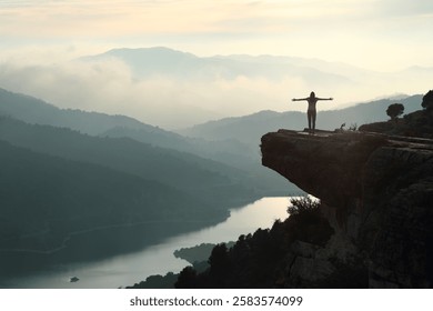 Woman outstretching arms in a cliff contemplating nature with copy space