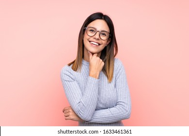 Woman Over Isolated Pink Background With Glasses And Smiling