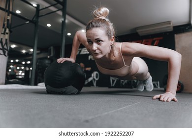 woman over thirty in the gym performs exercises under the guidance of an experienced woman trainer