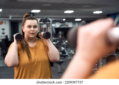 Woman With Overweight Lifting Dumbbells At The Gym