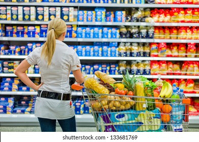 A Woman Is Overwhelmed With The Wide Range In The Supermarket When Shopping.