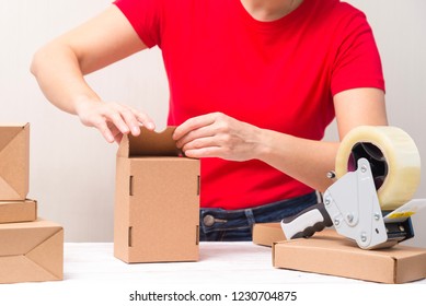 Woman packing cardboard boxes , picking and puttind products