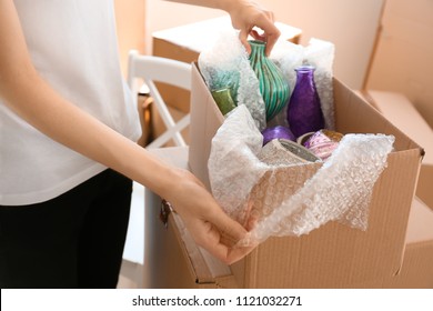 Woman Packing Carton Box Indoors. Moving House Concept