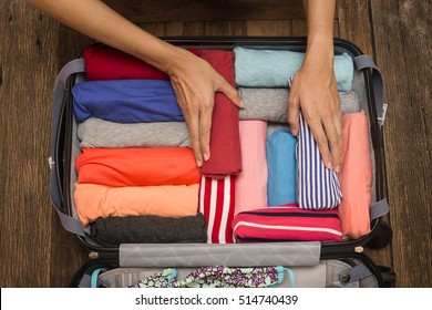 woman packing a luggage for a new journey - Shutterstock ID 514740439