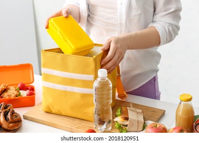 Woman Packing Meal Into Lunch Box Bag In Kitchen