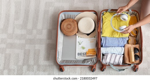 Mujer empacando maleta en casa, vista superior. Concepto de viajes