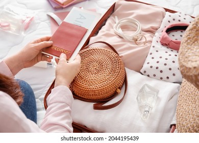 Woman packing suitcase on bed