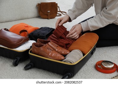 Woman Packing Suitcase For Trip At Home, Closeup