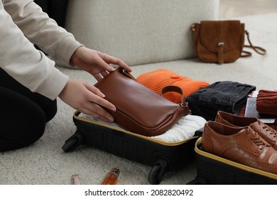 Woman Packing Suitcase For Trip At Home, Closeup