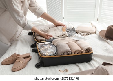 Woman Packing Suitcase For Trip On Bed, Closeup