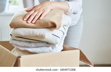 Woman Packs Clothes For A Clothes Donation In A Box Or Tidies Up