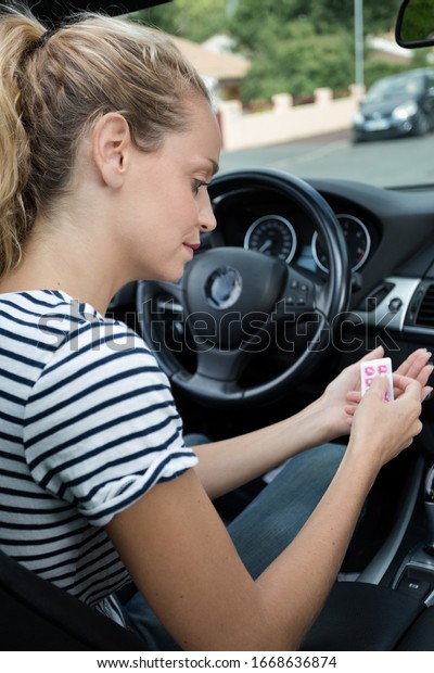 woman with packs of\
tablets while driving