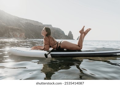 Woman Paddleboard Ocean Relaxing on Stand Up Paddleboard in Calm Sea near Rocky Coastline. - Powered by Shutterstock