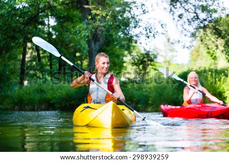 Woman paddling with canoe on forest river