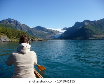 Woman Paddling To Engabreen, Svartisen Glacier Over Holandsfjord In Norway