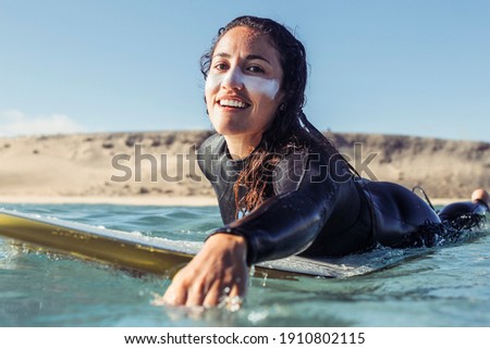 Woman paddling in the sea - Sportive girl surfing in the Atlantic ocean, on a sunny day with blue sky and transparent waves 商業照片 © 