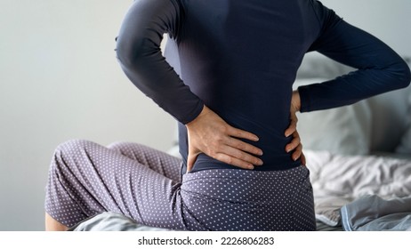 Woman with pain in back - Shutterstock ID 2226806283