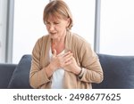 Woman with pain on heart, Mature female presses hand to chest has heart attack suffers from unbearable pain