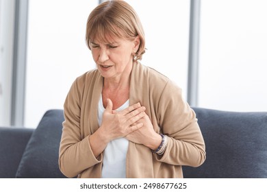 Woman with pain on heart, Mature female presses hand to chest has heart attack suffers from unbearable pain - Powered by Shutterstock