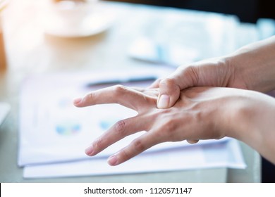 Woman painful finger due to prolonged use of keyboard and mouse.