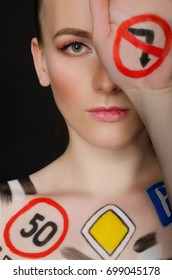 woman with painted road signs, dark background - Shutterstock ID 699045178