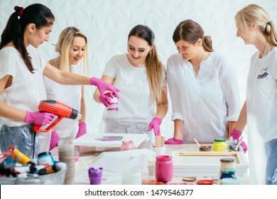 Woman Painter Holding Hair Dryer While Female Beginnres Studying Creating Fluid Acrylic Abstract Painting In Art Therapy Class, Dropping Paints On Canvas. Teamwork, Study, Art Therapy Concept.